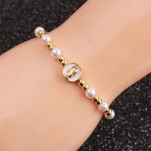 Bohemian pearl and gold bead bracelet featuring a circular Virgin Mary relief charm
