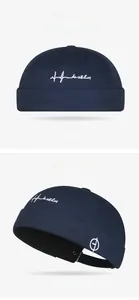 Détail du bonnet docker bleu marine avec broderie de ligne de cœur et boucle en métal