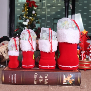 Macro detail of red flocked Christmas candy boots in four sizes with white plush trim