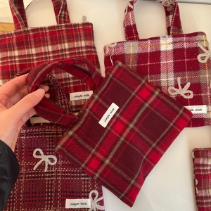 Détail du tissu en laine tartan rouge avec un nœud blanc et l'étiquette de marque