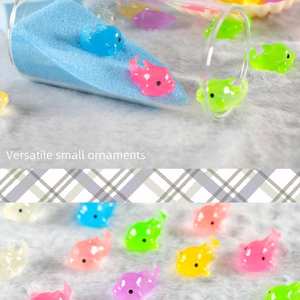 Close-up of colorful resin mini dolphin ornaments scattered on white plush background