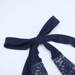 Detail of dark blue evening dress showing lace stitching and elegant bow tie design