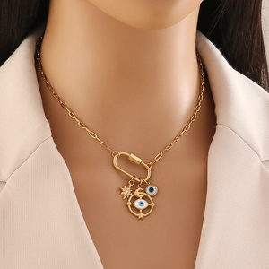 Gold star and evil eye carabiner pendant necklace on model with beige blazer