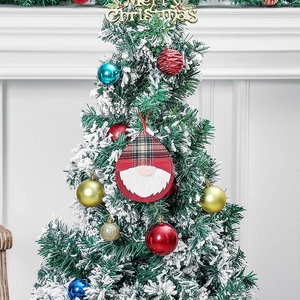 Plush Christmas gnome hanging ornaments on a snowy tree with Merry Christmas sign