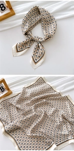Detail view of cream satin square scarf with black and brown geometric monogram pattern