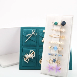 Green and beige velvet hair clip display boards showing various hair accessories and pins