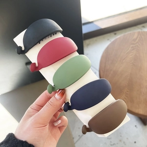 Close-up of five matte hair banana clips in black, burgundy, green, blue, and brown