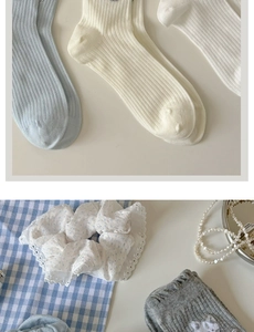 Détail d'un chouchou en dentelle à pois bleus et de chaussettes pastel douces