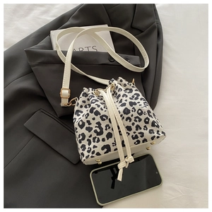 Détail du sac seau à motif léopard avec cordon de serrage et pieds en métal doré