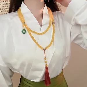 Collier long ethnique perlé avec beignet de jade vert, pompon rouge et perles jaunes