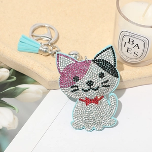 Detail of a sparkling crystal-encrusted cat keychain with a light blue tassel accessory