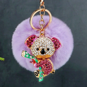 Détail d'un porte-clés pompon violet avec un charm koala incrusté de strass colorés