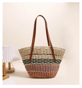 Détail du sac cabas rayé en paille tissée avec anses en cuir marron élégantes