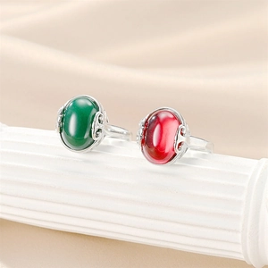 Detail of vintage palace style titanium steel rings with green and red oval gemstones