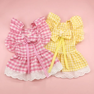 Detail of pink and yellow plaid pet dresses with white lace edges and cute bow accents