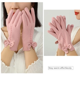 Detail of warm pink gloves with bow decoration and touchscreen embroidery on the finger