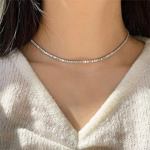 Close-up of minimalist silver choker necklace with sparkling zircons on female neck