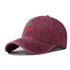Detailed side view of washed burgundy cotton baseball cap with embroidered cherry design
