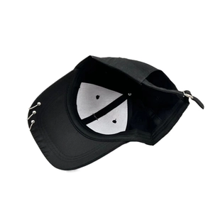 Black street style baseball cap with metal rings on brim from a 45-degree angle
