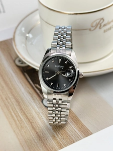 Elegant women's watch with black dial and silver steel band shown in a cozy setting