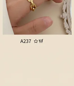 Close-up of a minimalist chunky gold chain link ring worn by a model on hand