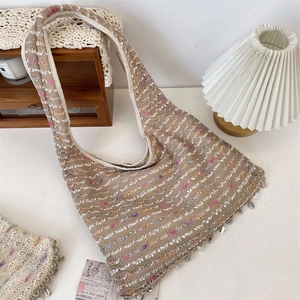 Detailed knit shoulder bag featuring colorful cords, sea shells and shiny silver sequins
