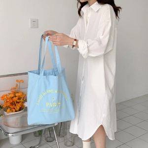 Detail of light blue canvas tote bag featuring yellow PARIS flower embroidery