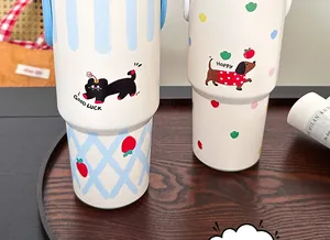 Close-up of 40oz insulated tumblers with handles, cat and dachshund patterns on wooden tray