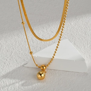Detail of 18K gold-plated double-layer necklace with snake chain and spherical pendant