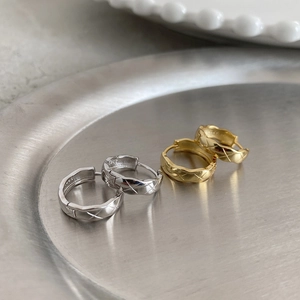 Close-up of geometric S925 sterling silver hoop earrings with quilted diamond pattern