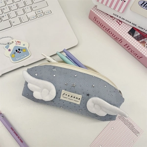 Dettaglio dell'astuccio azzurro con ali di peluche bianche e motivi a stelle argentate