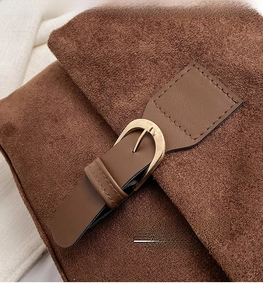 Macro view of brown suede texture with smooth leather strap and gold pin buckle detail