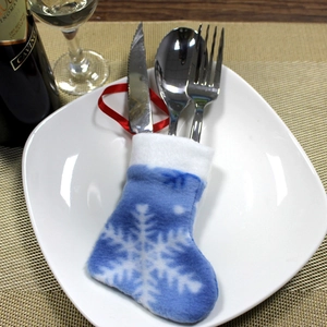 Close-up of blue snowflake felt Christmas stocking cutlery holder on a white ceramic plate