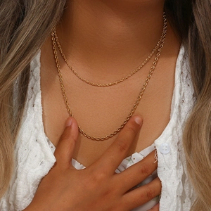 Gros plan de chaînes torsadées en acier inoxydable plaqué or 18 carats sur un mannequin