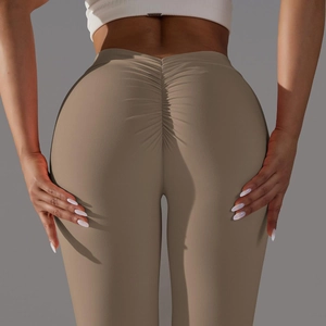 Détail macro du pantalon de yoga taille haute montrant le design froncé et le tissu stretch
