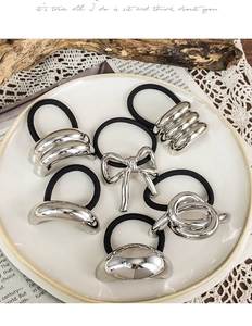 Detail view of 6-piece silver metal hair ties set featuring bow and geometric shapes