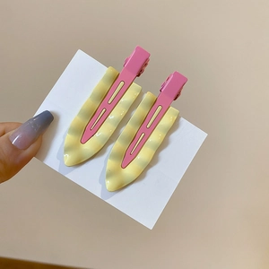 Detail of pink and cream wavy resin hair clips with a metal duckbill side clip design