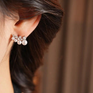 Detailed view of silver crawler earring featuring gradient pearls and sparkling zircon stones