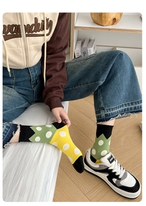 Detail of polka dot combed cotton socks in green and yellow contrast colors