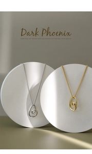 Detailed view of gold and silver irregular twisted double ring pendants on pedestals