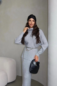 Detail of grey knitted high neck sweater and maxi skirt showing rib-knit texture
