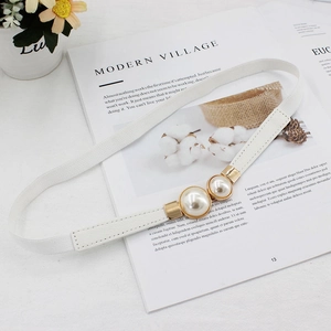 Elegant white woven belt for women featuring gold double pearl buckle on a magazine