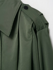 Detailansicht der olivgrünen Jacke mit Schulterklappen, schwarzen Knöpfen und Köperbindung