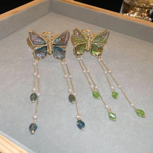 Elegant butterfly hair clips with faux pearls and long crystal tassels in a 45-degree view