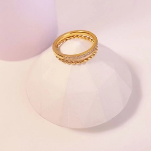 Detail of gold double-layer ring featuring twisted rope design and white zircon stones