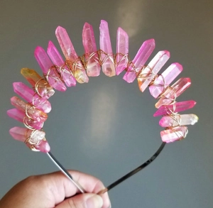 Dettaglio dei cristalli di quarzo rosa e arancio avvolti in filo dorato su un cerchietto