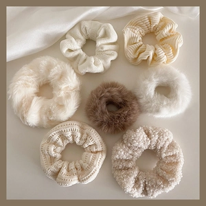 Detail of 7-piece plush scrunchie set in cream tones showing various soft textures