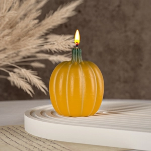 Handmade 3D yellow pumpkin scented candle with green stem for festive Halloween decor