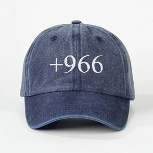 Detailed view of the 3D white +966 embroidery on the washed navy denim baseball cap
