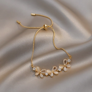 Detail of adjustable gold bracelet featuring opal butterflies and sparkling zircon accents